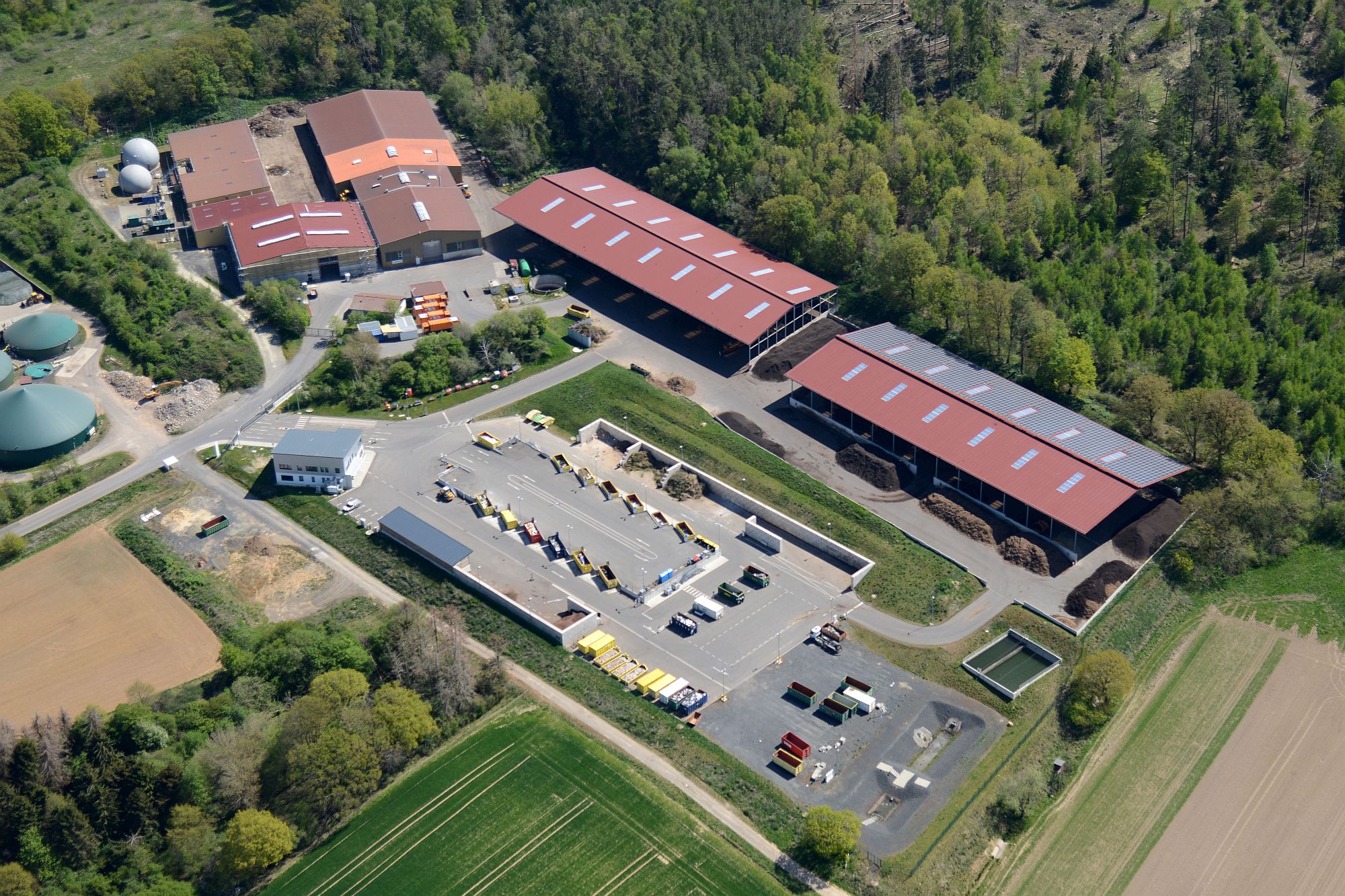 Kompost-Traktor auf Feld grüner Traktor mit Kompost-Anhänger auf gelbem Feld